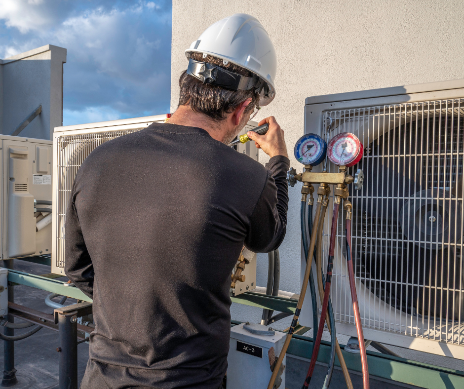 A maintenance tech working on a commercial air conditioning unit