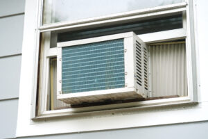 Window unit air conditioner installed on house window